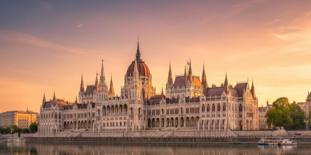 Le Parlement hongrois illuminé au-dessus du Danube à l'heure bleue, vu depuis la rive de Buda