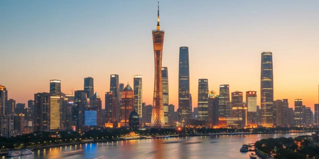 La Canton Tower illuminée de couleurs au-dessus de la rivière des Perles la nuit, avec les gratte-ciel de Zhujiang New Town en arrière-plan