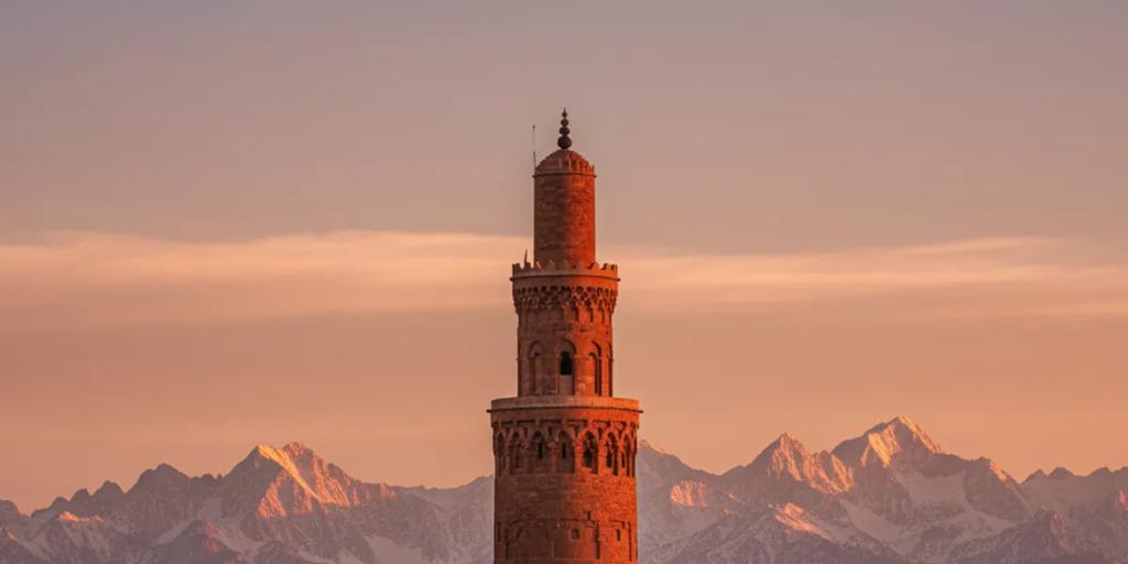 Toits de la médina de Marrakech avec le minaret de la Koutoubia et les montagnes de l'Atlas saupoudrées de neige au loin