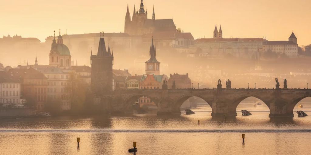 Les statues du pont Charles et le château de Prague émergeant de la brume matinale
