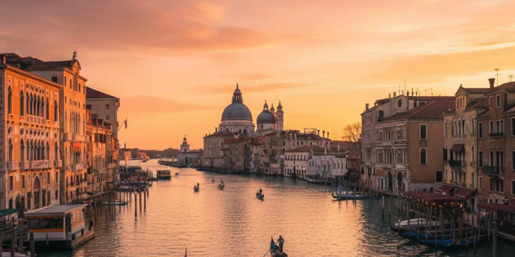 Gondoles amarrées sur le Grand Canal au crépuscule, avec les coupoles de la Salute en arrière-plan